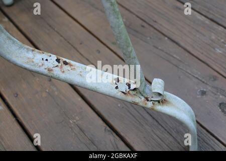 Paint Chipping over Rust Spots on a Metal Table Leg Stock Photo