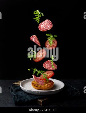 Creative concept with falling food on black backdrop Stock Photo