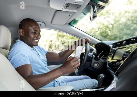 Positive african american driver using mobile phone Stock Photo
