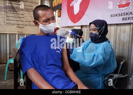 Bekasi, Indonesia. 04th Aug, 2021. (11/30/0001) A health worker injects a Covid-19 vaccine using the Astrazeneca type to a patient with Mental Disorders at the Jamrud Biru Foundation, Bekasi City, West Java, Indonesia. They were assessed to be a vulnerable group of people with a significantly higher risk of severe illness or death. (Photo by Kuncoro Widyo Rumpoko/Pacific Press/Sipa USA) Credit: Sipa USA/Alamy Live News Stock Photo