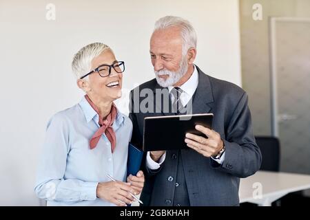 senior busniess people talking office communication meeting teamwork gray hair active colleague happy Stock Photo