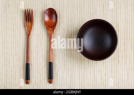 Wooden Spoon, Fork and Plate on a Bamboo Backing. Asian food handicraft concept. View from above Stock Photo