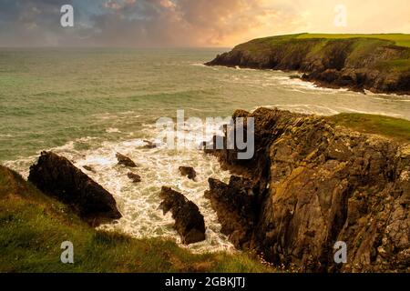Beautiful sunset with colorful clouds over shoreline of the Irish Sea. Stock Photo