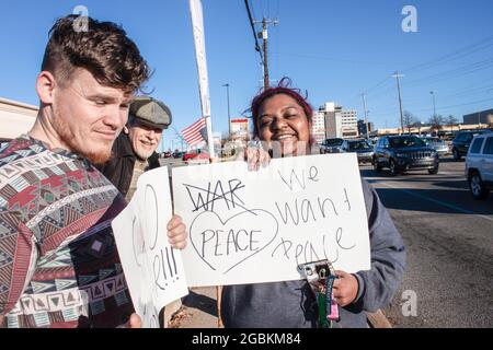 01-04-2020 Tulsa USA - Three multi cultural and generational smiling protesters with anti-war signs stand near intersection Stock Photo