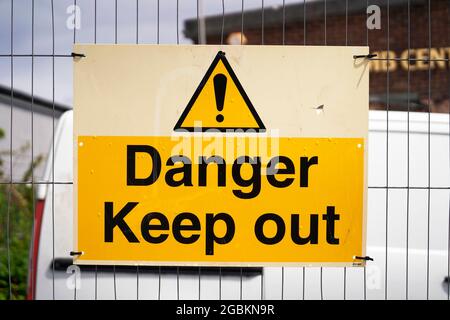 Danger keep out sign attached to a wire fence with cable ties Stock Photo