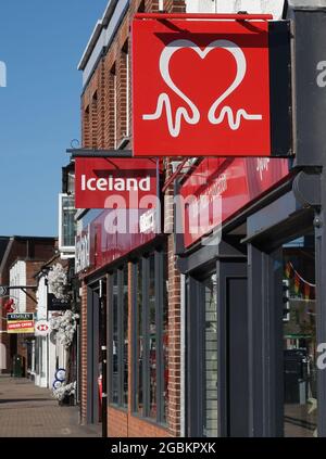 BILLERICAY, UNITED KINGDOM - Jun 13, 2021: A vertical shot of the British Heart Foundation charity shop and Iceland store along the street Stock Photo