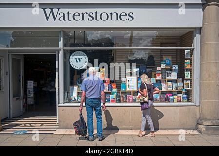 Potential customers looking at the display of books in the window of Waterstones Bookshop on Princes Street, Edinburgh, Scotland, UK. Stock Photo