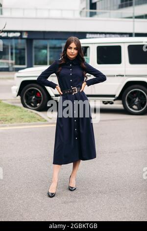 Attractive elegant woman in black belted dress. Stock Photo
