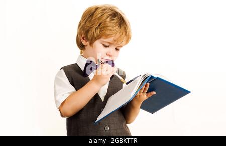 Child writing in notebook. Schoolboy in school uniform. Back to school. Stock Photo