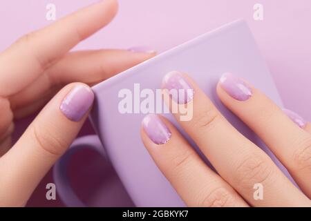 Womans hand with trendy lavender manicure. Spring summer nail design
