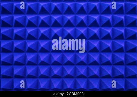 rows of acoustic music soundproof foam pyramid panel with blue lighting. Stock Photo