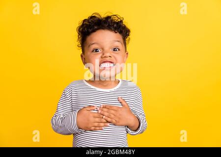 Photo portrait small boy smiling wearing casual striped shirt isolated vivid yellow color background Stock Photo