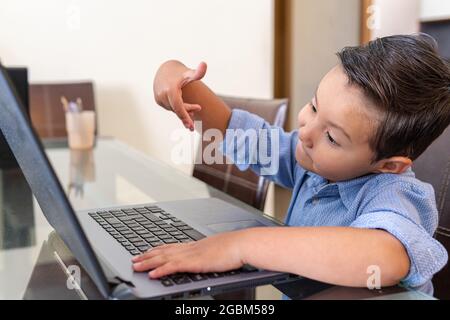Preschooler gesturing in conversation on laptop at home Stock Photo