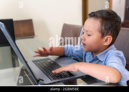 Boy doing homework on a laptop at home Stock Photo