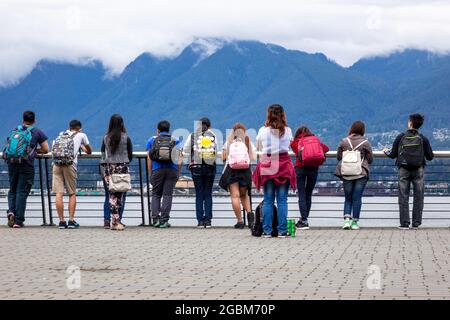 Teenage School Children Tourists Looking At Vancouver Harbour At The Vancouver Convention Centre Stock Photo