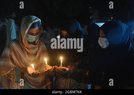 Lahore, Pakistan. 04th Aug, 2021. Chief Traffic Officer (CTO) Muntazir Mehdi, CCPO Ghulam Muhammad Dogar, DIG Imran, Women traffic police officials and others light the candles during a candle-light ceremony in connection with “National Police Martyrs Day” in the remembrance of Punjab Police martyrs, who laid down their lives for peace in the country” in Lahore. (Photo by Rana Sajid Hussain/Pacific Press) Credit: Pacific Press Media Production Corp./Alamy Live News Stock Photo