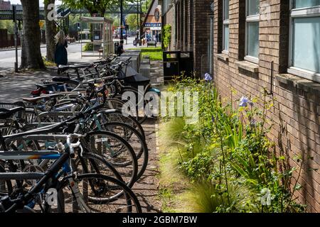 A row of 'Sheffield stand' cycle racks placed prominently and conveniently outside the main entrance of a building, with space for non-standard cycle Stock Photo