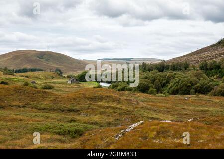 A ruined cottage stands in a glen beside the River Oykel under the mountains of Sutherland in the Highlands of Scotland. Stock Photo