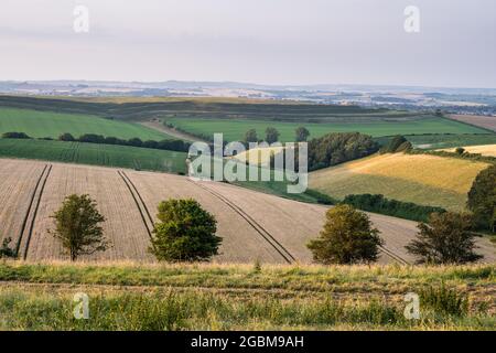 The iron age hill fort of Maiden Castle rises among the rolling hills of the Dorset Downs near Dorchester. Stock Photo