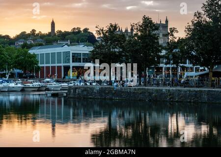 People drink on the quaysides of Bristol's Harbouside nightlife neighbourhood at sunset. Stock Photo