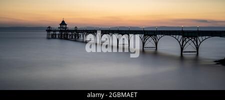 The sun sets over the Bristol Channel and South Wales at Clevedon Pier in Somerset, England. Stock Photo