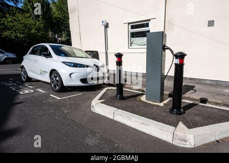 An electric 'car club' share car charges at an on-street charger in a residential street in Easton, Bristol. Stock Photo