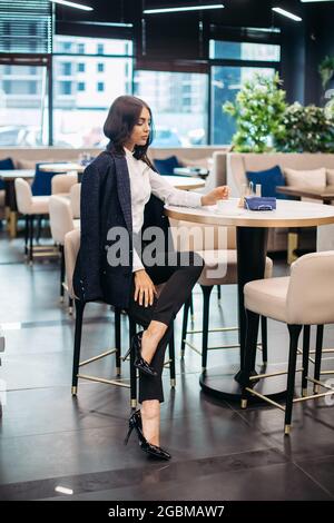 Pretty young lady in classic clothes in a restaurant Stock Photo