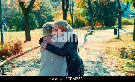 Grandmother and granddaughter hugging each other in park. They happy to spend time together and walking outdoors. Stock Photo