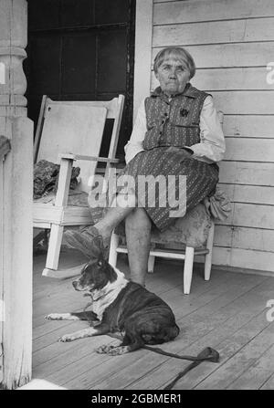 Hearn, Texas USA, 1978: Elderly woman sits on her front porch with her dog in small town in south-central Texas. ©Bob Daemmrich Stock Photo