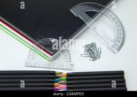 foreground of set of school tools with colored self-tips pens, clips, notebooks and ruler on white background Stock Photo