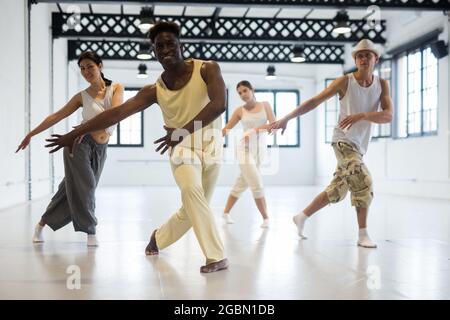 People practicing vigorous lindy hop movements in dance class Stock Photo