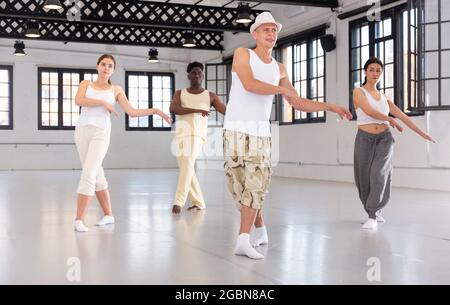 Portrait of smiling young dancing people practicing vigorous swing in studio Stock Photo
