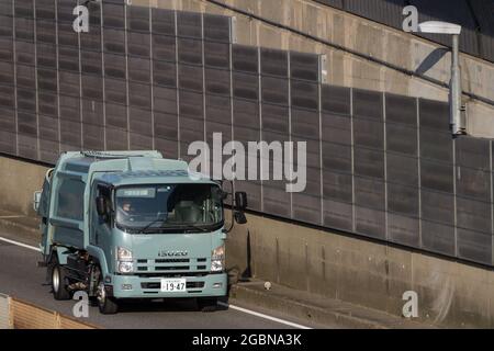 An Isuzu N series garbage truck on a road near Tsuruma, Kanagawa, Japan. Stock Photo