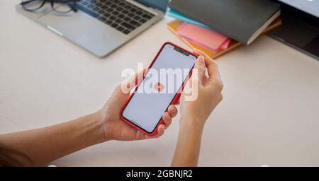 CHIANG MAI, THAILAND - MAY 23, 2021 : hand is pressing the screen displays the Youtube app icons on Apple iPhone. YouTube is the popular online video Stock Photo