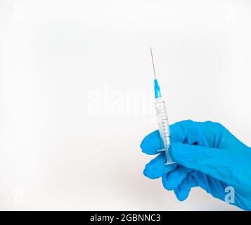 The doctor holds a vaccination syringe on a white background. A shot from the coronovirus. Vaccination against dangerous infections or treatment of di Stock Photo
