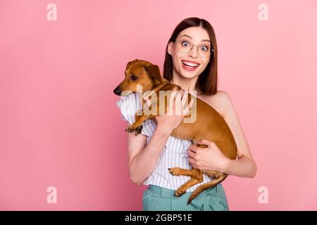 Photo of impressed brunette young lady hug dog wear eyewear white top isolated on pink color background Stock Photo