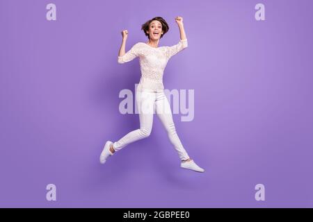 Photo Of Lucky Excited Lady Dressed Sweater Sitting Table Rising Fists 