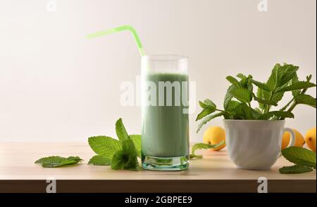 Milk shake with mint on wooden table and mint leaves isolated white background Front view. Stock Photo