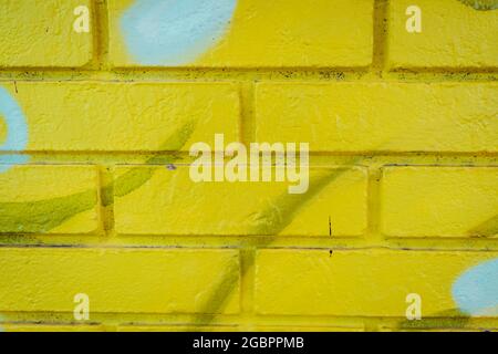 Yellow brick wall with light blue spots on it Stock Photo