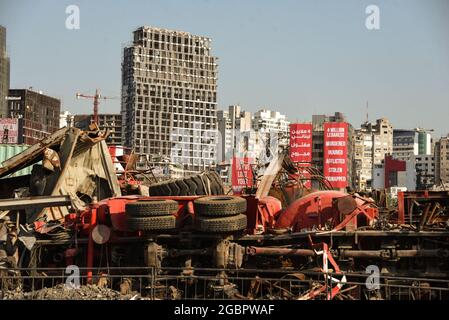 Beirut, Lebanon, 4 August 2021. Damaged buildings of Beirut's Gemmayze district seen from behind a pile of twisted metal in the capital's port on the one year anniversary of the Beirut Blast. An eplosion often described as one of the largest non-nuclear blasts in history. Stock Photo