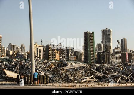 Beirut, Lebanon, 4 August 2021. Damaged buildings of Beirut's Gemmayze district seen from behind a pile of twisted metal in the capital's port on the one year anniversary of the Beirut Blast. An eplosion often described as one of the largest non-nuclear blasts in history. Stock Photo