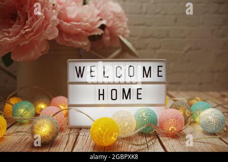Welcome Home text on lightbox on wooden background Stock Photo
