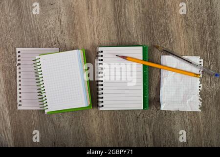 Torn sheets with notebooks and writing utensils Stock Photo