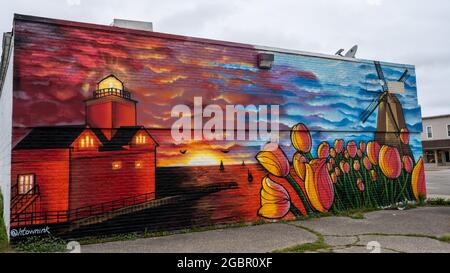 Sammy's Place mural (tulips, DeZwaan Windmill, sunset on the beach, Big Red lighthouse)., in Holland, Michigan. Artist, Chris Garcia Stock Photo