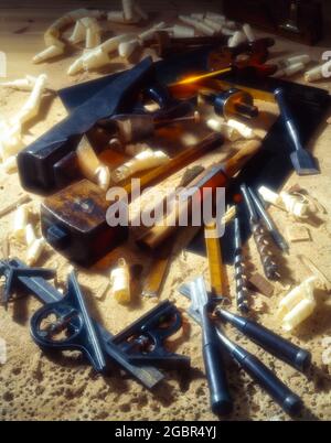 Traditional wood working tools with sawdust and wood shavings upright format with mallet plane hammer spoke shave chisels vintage tools Stock Photo