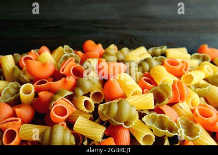 Pile of Three-color Dried Vegeroni Pasta on Black Background with Copy Space Stock Photo