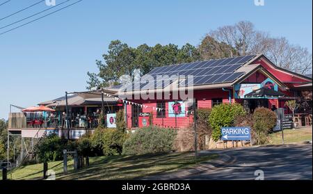 Cafe and other businesses in North Tamborine, on Tamborine Mountain, Australia. Bright colours, solar panels on roof, winter sunshine. Stock Photo