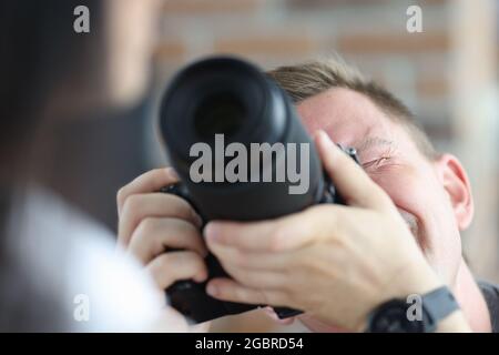 Man photographing woman using black professional camera Stock Photo