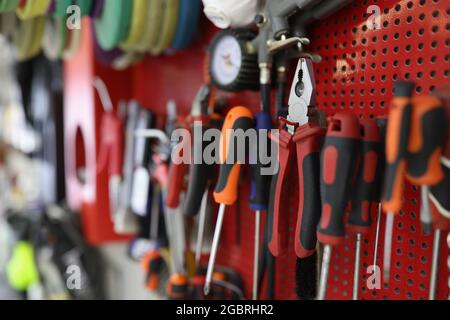 Many working tools hanging on wall in workshop closeup Stock Photo