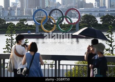 Tokio, Japan. 05th Aug, 2021. Visitors take pictures of the Olympic rings. Credit: Swen Pfoertner/dpa/Alamy Live News Stock Photo